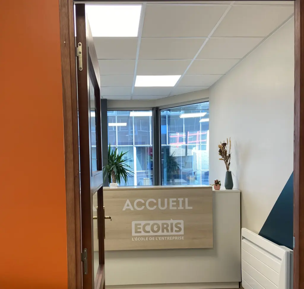Accueil de l'école Ecoris, espace d'entrée moderne avec comptoir en bois et décoration sobre.