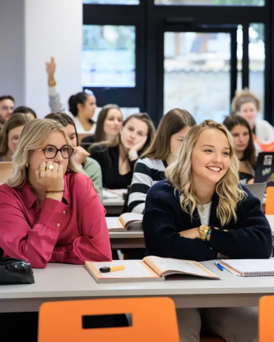 Des étudiantes attentives et souriantes en salle de classe, suivant un cours interactif