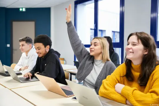 Étudiants en classe à Ecoris, une élève lève la main pour poser une question pendant un cours.