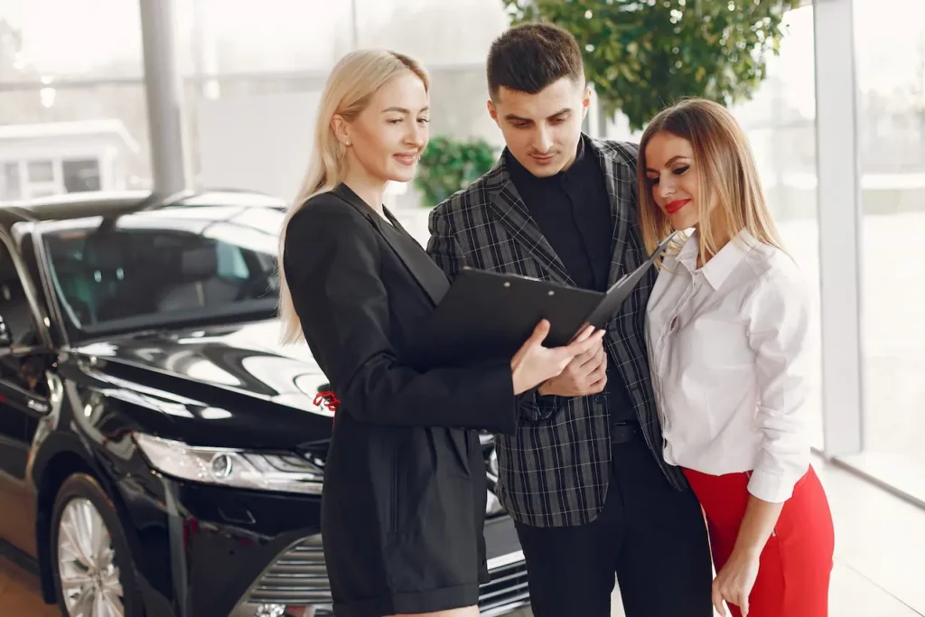 Vendeur professionnel dans un concessionnaire automobile, illustrant la formation en vente automobile proposée par Ecoris.
