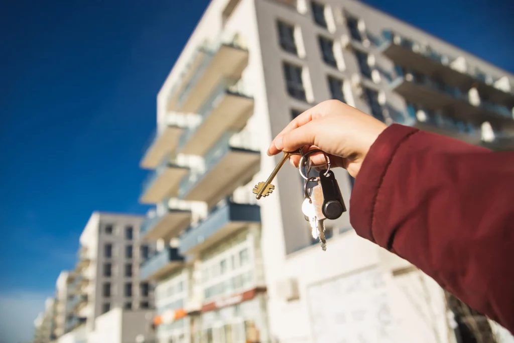 Main féminine tenant les clés d’un nouvel appartement, illustrant la réussite d’une formation en immobilier chez Ecoris.