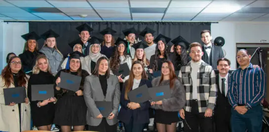 Remise des diplômes des étudiants d'Ecoris avec toges et certificats en main.