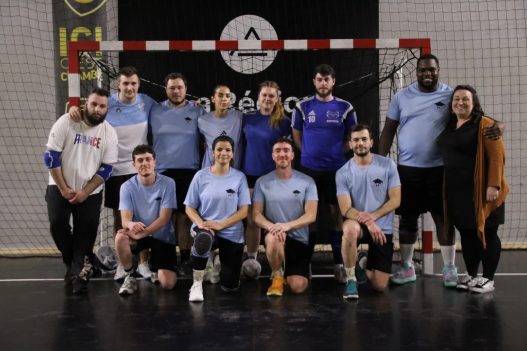 Équipe de handball d'Ecoris participant à la Business Cup 2025, posant devant un but dans une salle de sport.