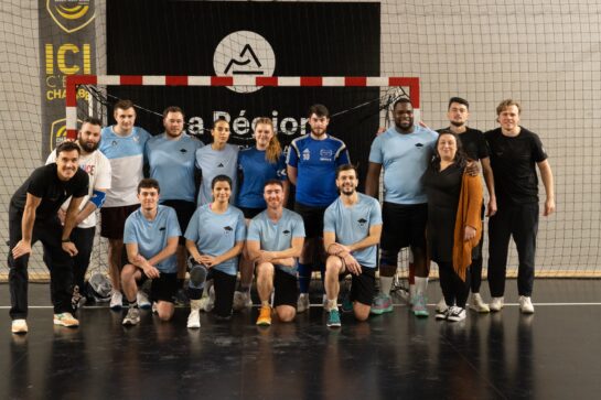 Les joueurs de l’équipe de handball Ecoris posent devant une cage aux côtés de trois joueurs professionnels lors de la Business Cup 2025.
