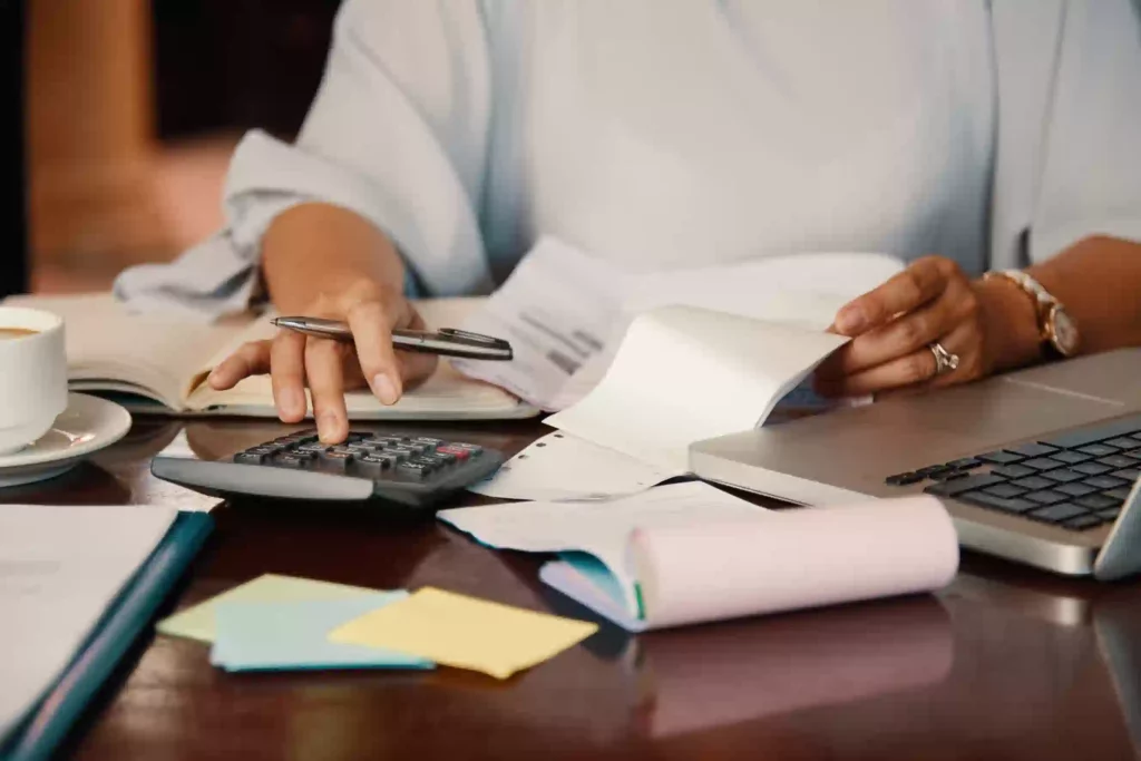personne dans son bureau entrain de taper a la calculatrice