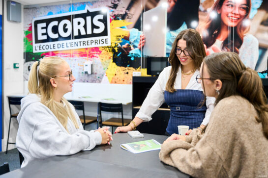 Trois étudiantes discutent autour d’une table dans les locaux d’ECORIS Lyon.